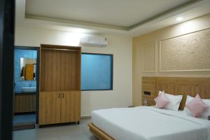 a bedroom with a large white bed and a bathroom at Hotel Starwing in Pāonta Sāhib