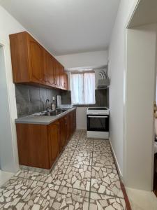 a kitchen with wooden cabinets and a tile floor at Guest House Central Vlora in Vlorë