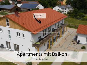 a building with a red roof with the words apartments hit ballatown at Holledau-Apartments - Auszeit im schönen Hopfenland in Bayern - voll ausgestattete Apartments - Garten - Balkon - Nähe München in Osterwaal