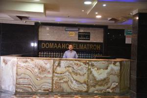 a man standing behind a counter in a building at Doma Hotel Matrouh in Marsa Matruh