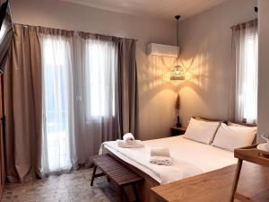 a bedroom with a bed with towels on it at Orfeas Luxury Rooms & Studio in Skopelos Town