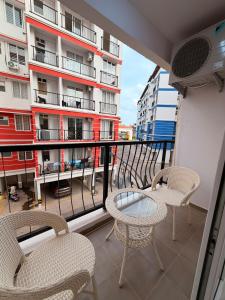 a balcony with chairs and a table and a building at Casa sol Goa 2BR Apt By Amoret Homes in Chicalim