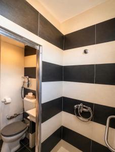 a bathroom with black and white stripes on the wall at Tófenék Deluxe Apartman in Szolnok