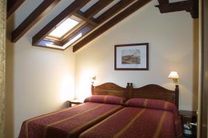 Apartamentos Villa de Potes في بوت: غرفة نوم بسرير ونور