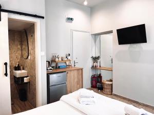 a bedroom with a bed and a tv on a wall at Orfeas Luxury Rooms & Studio in Skopelos Town +15 photos