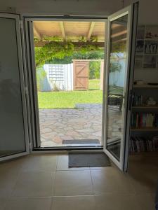 an open door to a patio with a door to a yard at Little Blue House in Sidari