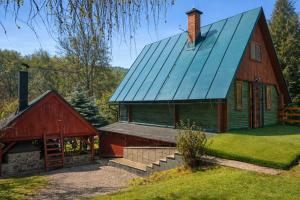 a barn with a red building and a red barn at Chata Kopánka in Moderštôlňa
