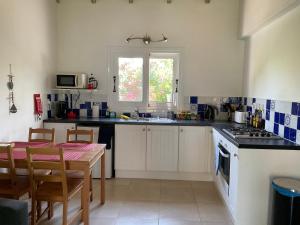 a kitchen with a table and a stove top oven at Little Blue House in Sidari