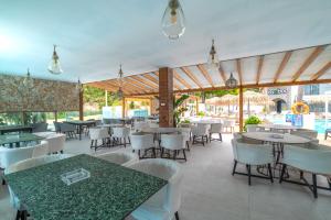 a restaurant with tables and white chairs and tablesearcher at Bamboo Suites Hotel - Adults Only in Ialysos