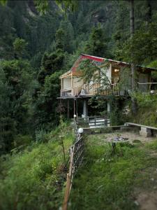 a house on the side of a hill at UrWish TreeHouse cottageJacuzzi in Jibhi +28 photos