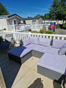 a white couch sitting on a wooden deck at Sunblast- Dawlish Warren in Cockwood