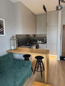 a kitchen with a table and two stools at Piska Przystań in Pisz
