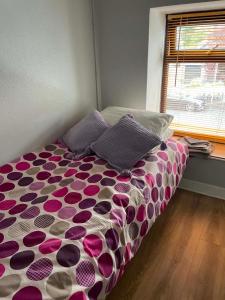 a bedroom with a bed with a purple and white comforter at 7 Main st in Camlough
