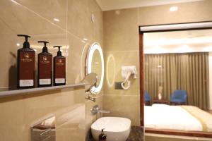 a bathroom with two bottles of soap and a mirror at The Pamir Hotel in Nubra