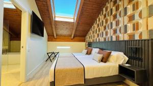 a bedroom with a large bed and a skylight at Soho Boutique La Harinera in Valladolid +40 photos