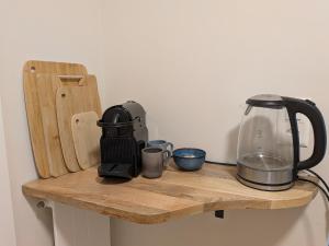 a wooden shelf with a blender and cups on it at Sunshine Suite in Ingenbohl