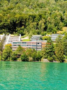 a building on the shore of a lake at Sunshine Suite in Ingenbohl