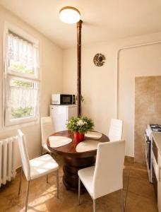 a kitchen and dining room with a table and chairs at Tófenék Deluxe Apartman in Szolnok