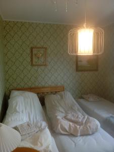 two twin beds in a bedroom with a light at Guest Room in Liviöjärvi
