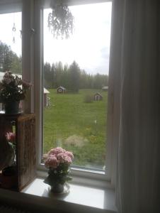 a window with flowers in a vase on a window sill at Guest Room in Liviöjärvi