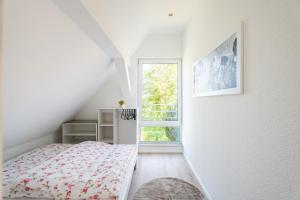 a white bedroom with a bed and a window at Häusle Fritz in Weier