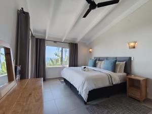 a bedroom with a large bed and a window at 4 Chaka's Rocks Chalets - The Beach Cottage in Ballito