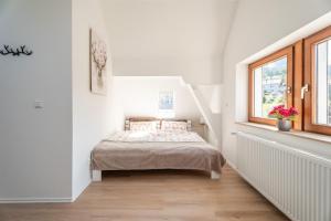 a bedroom with a bed in a white room at Häusle Felix in Weier
