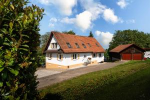 a white house with a red roof and a garage at Häusle Felix in Weier