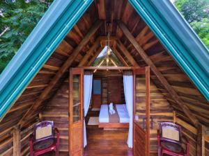 a bedroom in a tree house with two chairs at Mr Arachchi Luxury Cabana in Ella