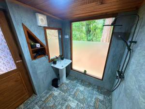 a bathroom with a sink and a window at Mr Arachchi Luxury Cabana in Ella
