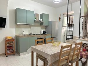 a kitchen with a table and chairs and a kitchen with green cabinets at La Minicasa in Pacentro +14 photos