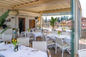 a restaurant with white tables and white chairs at Aparthotel All'Orologio in Peschiera del Garda