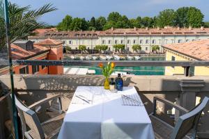 a table on a balcony with a view of a building at Aparthotel All'Orologio in Peschiera del Garda