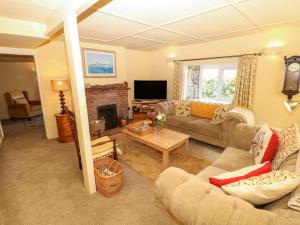 a living room with a couch and a fireplace at Sweet Briars in Chalegreen