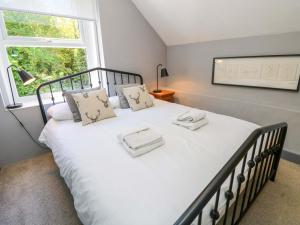 a bedroom with a large white bed with a window at Sweet Briars in Chalegreen
