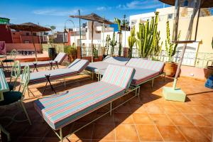 a group of lounge chairs sitting on a roof at Wave chaser surfhouse morocco in Agadir