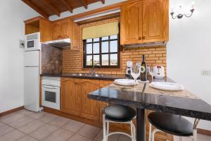 a kitchen with wooden cabinets and a counter with stools at Home2Book Las Tinajas A, Peaceful Retreat in Triquivijate