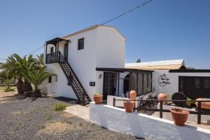 a white house with a staircase in front of it at Home2Book Las Tinajas A, Peaceful Retreat in Triquivijate