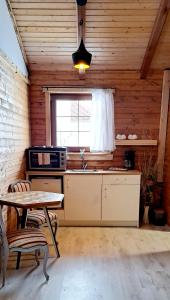 a kitchen with a table and a sink and a window at Etno wooden room in Rakovica