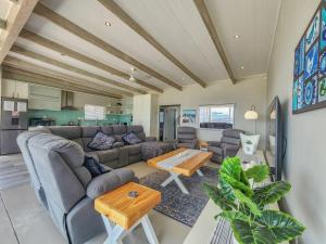 a living room with a couch and a table at 8 On Fleur Park Beach in Gordonʼs Bay