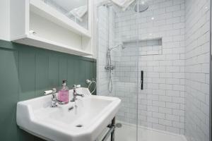 a white bathroom with a sink and a shower at Cottage 298 - Clifden in Clifden +32 photos