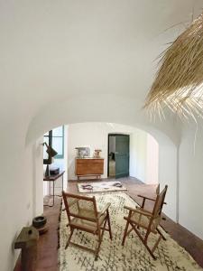 a living room with two chairs and a table at Casa Pimenta in Vidigueira