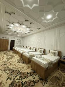 a row of beds in a large room at Silk Road Hostel in Bukhara +11 photos
