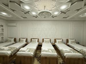 a room with four beds and a chandelier at Silk Road Hostel in Bukhara