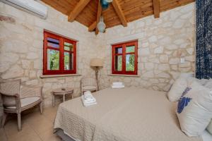 a bedroom with a bed and a stone wall at Nephele 3 bedroom villa with private pool in Akrotiri +23 photos
