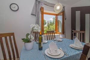 a table with a blue table cloth and a bottle of wine at Lucia in Gračišće - Istrien in Gračišće