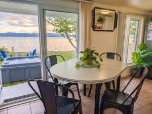 a table and chairs in a room with a view of the water at Chalet #2 Waterfront with Spa, Fireplace Wifi & AC in Cap-Saint-Ignace