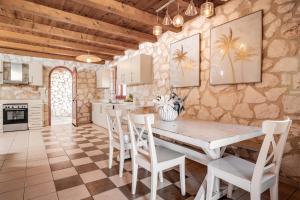 a kitchen with a wooden table and chairs at Nephele 3 bedroom villa with private pool in Akrotiri