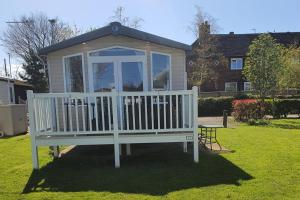 a large white gazebo in the yard of a house at 3-Bed Caravan Sleeps 8 with Enclosed Decking in Fleetwood