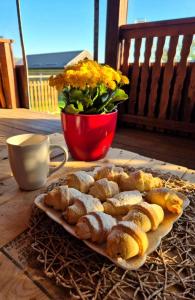 a tray of pastries on a table with a bowl of flowers at Kuća za odmor Mia in Gornja Gračenica +9 photos